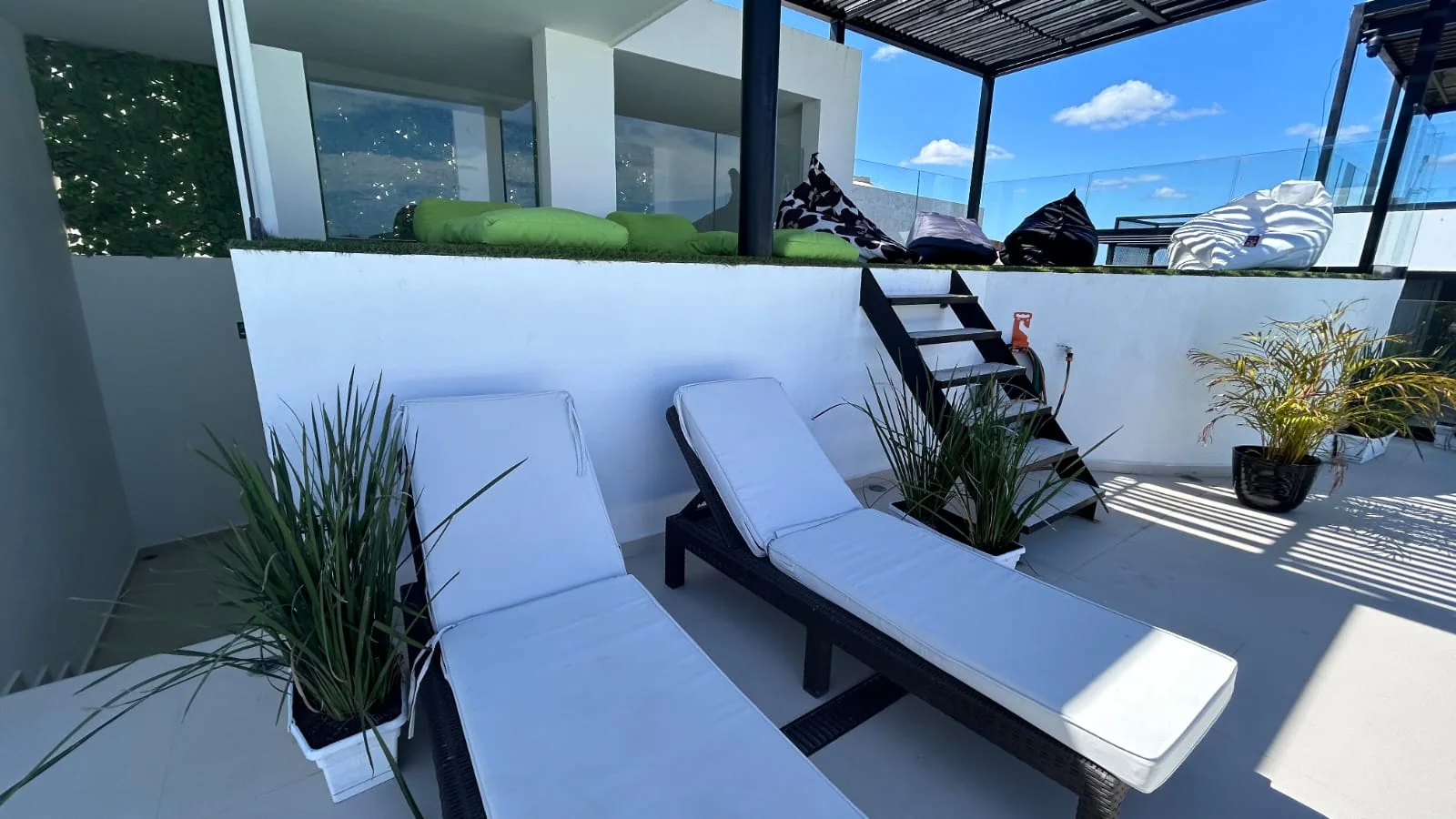 Terraza con camastros blancos y plantas en Black & White, La Veleta